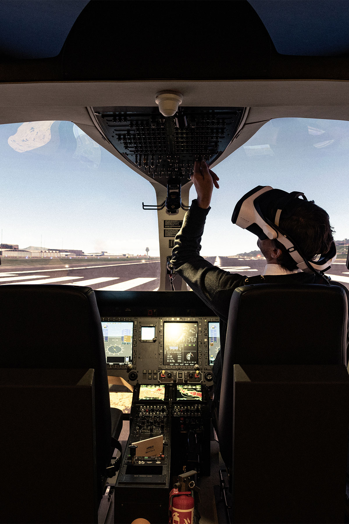 a person sitting in a cockpit, wearing an XR headset.